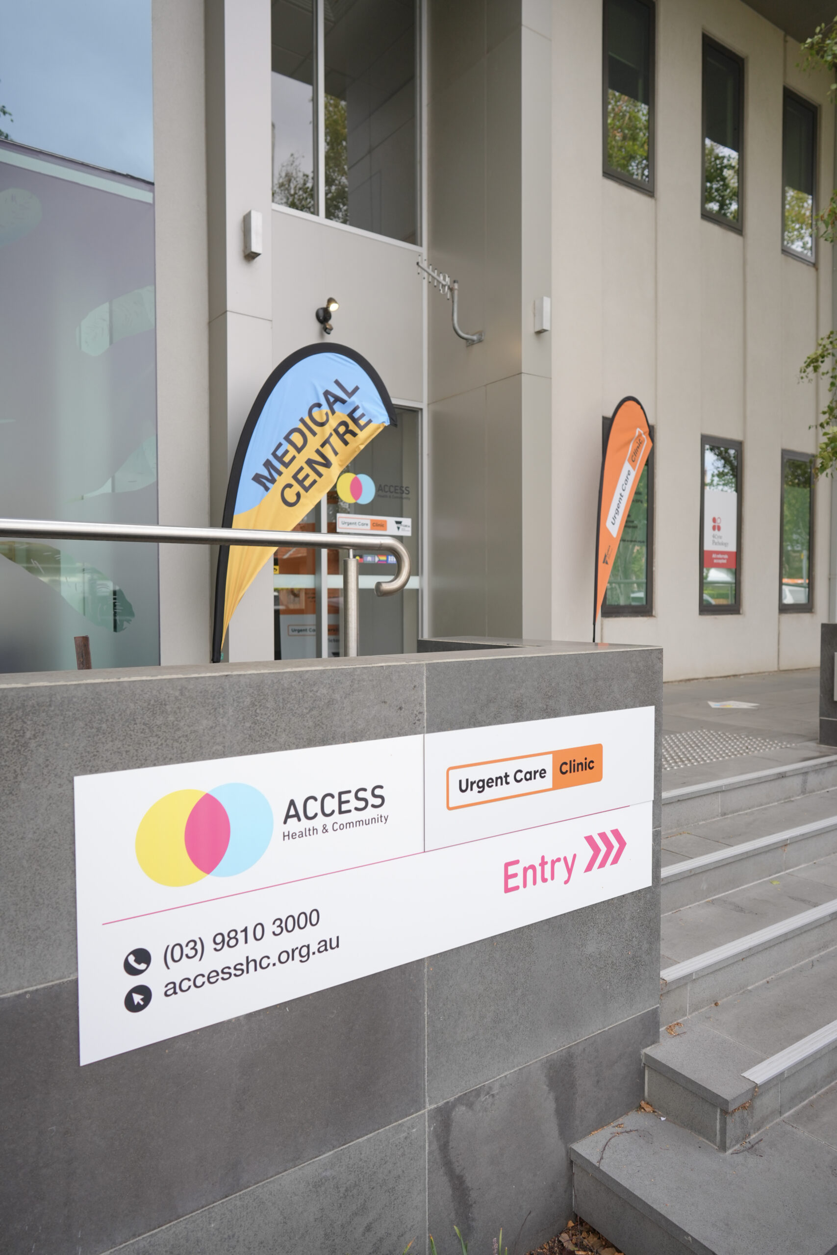 Entry to AccessHC Richmond with stairs, a ramp and colourful signage