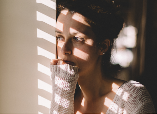 Young woman thinking and looking out window